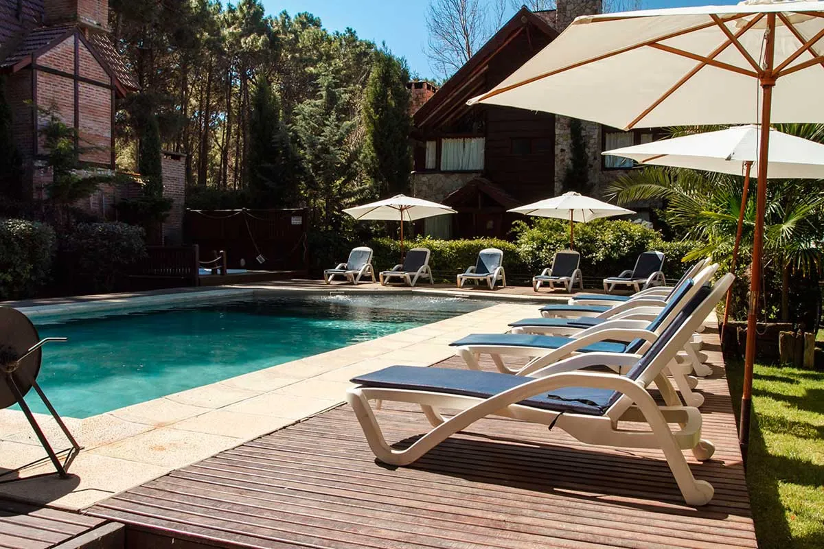 Solárium con reposeras, sombrillas estilo jardín y piscina principal.